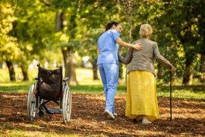 Older adult and family member speaking with a staff member in a bright assisted living common room.