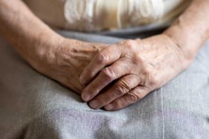Older adult and family member reviewing an assisted living fee sheet at a kitchen table.